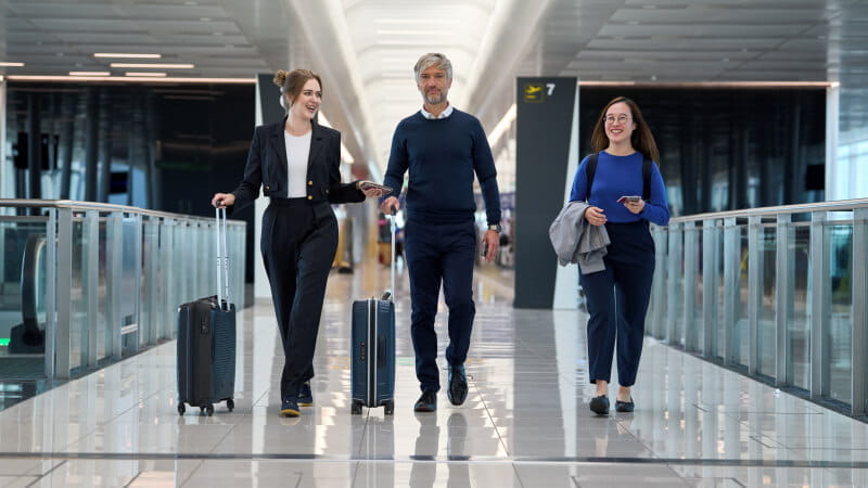 businesswomen and businessman walking with luggage in airport