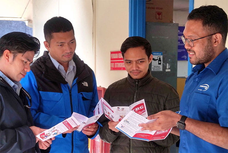 Four men from International SOS Medical Staff looking at brochure