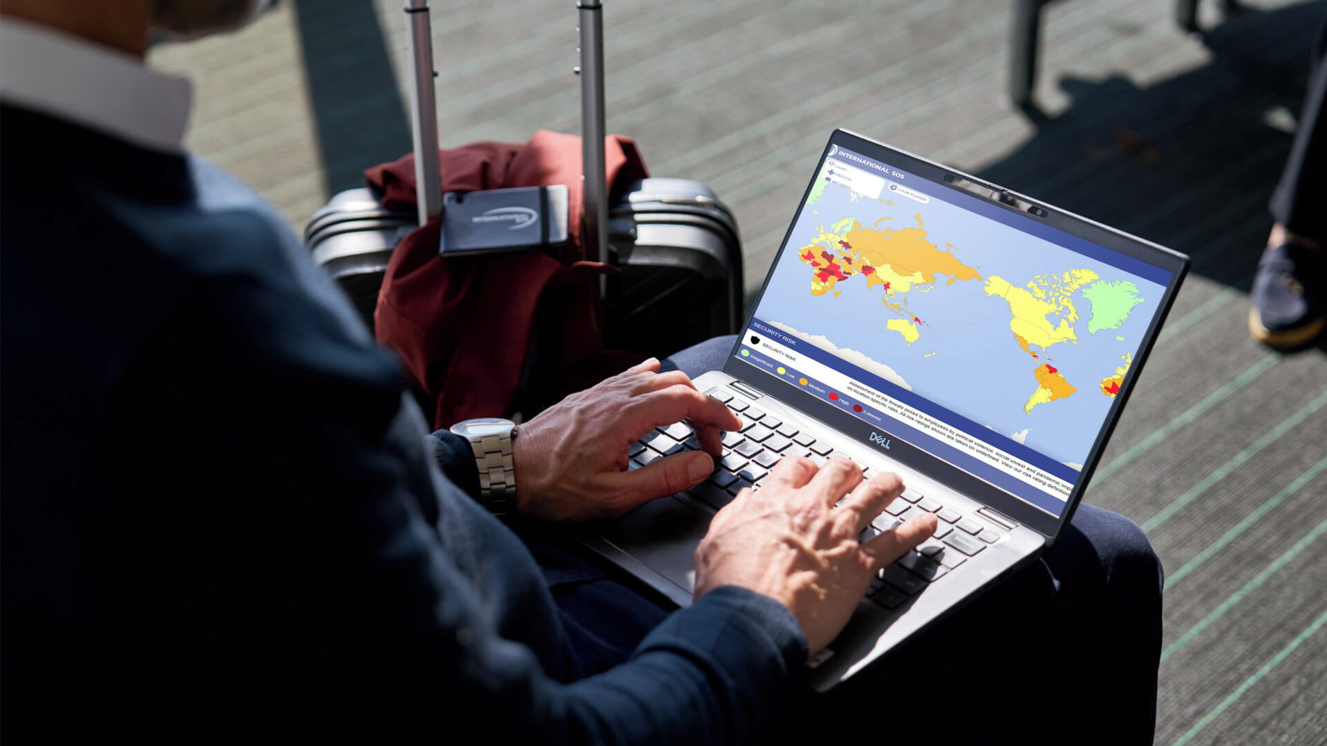 male business traveller at airport looking at risk map in his pc