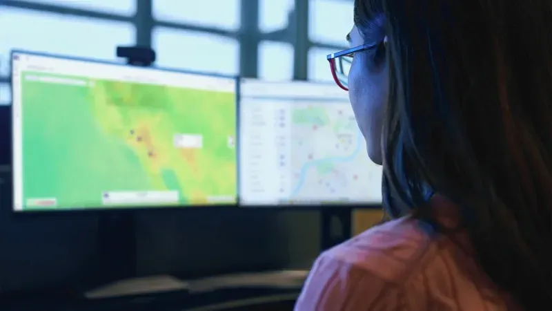 security analyst looking at two monitors in the London assistance center